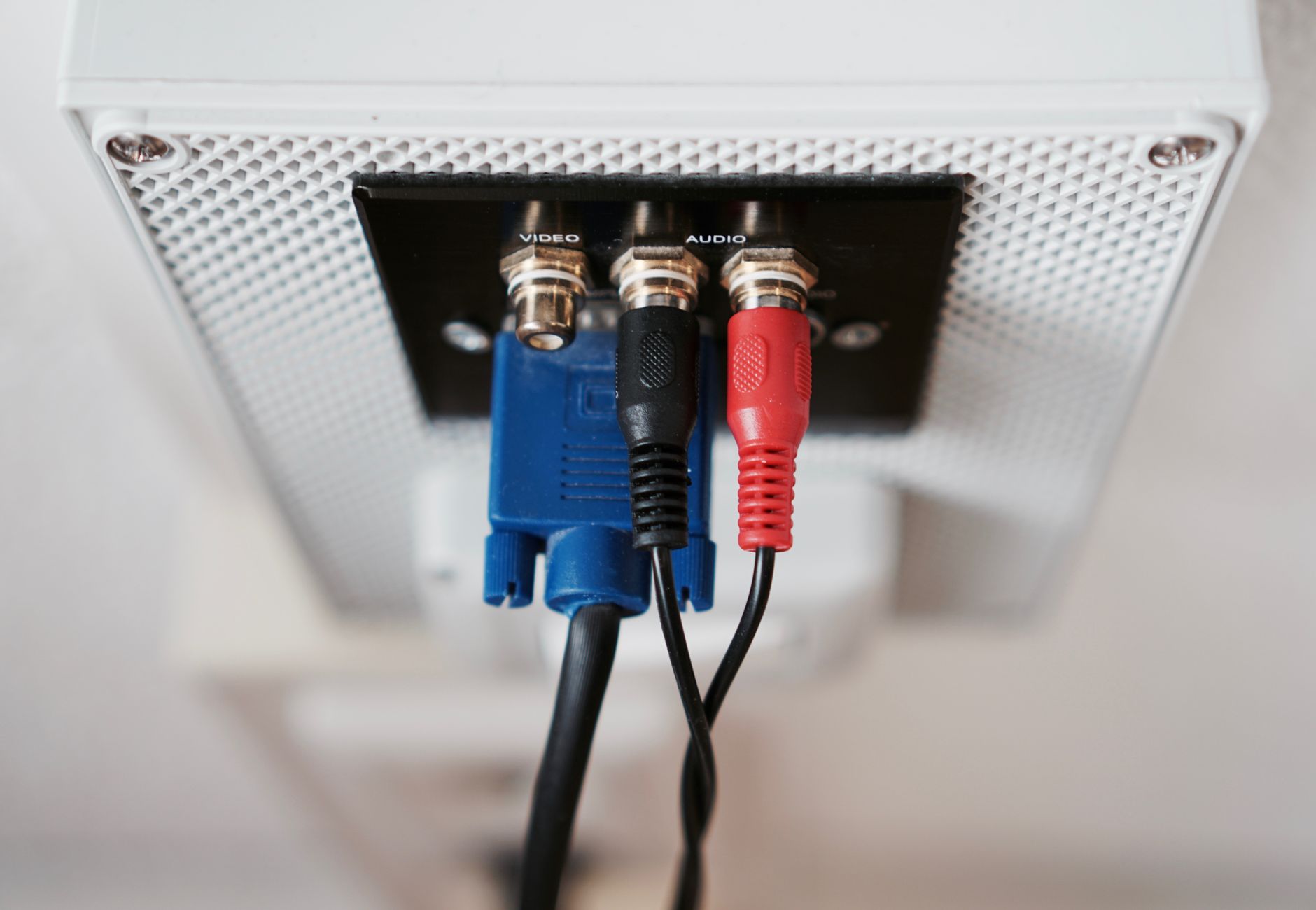 Detailed view of audio and video input cables connected to a wall socket.