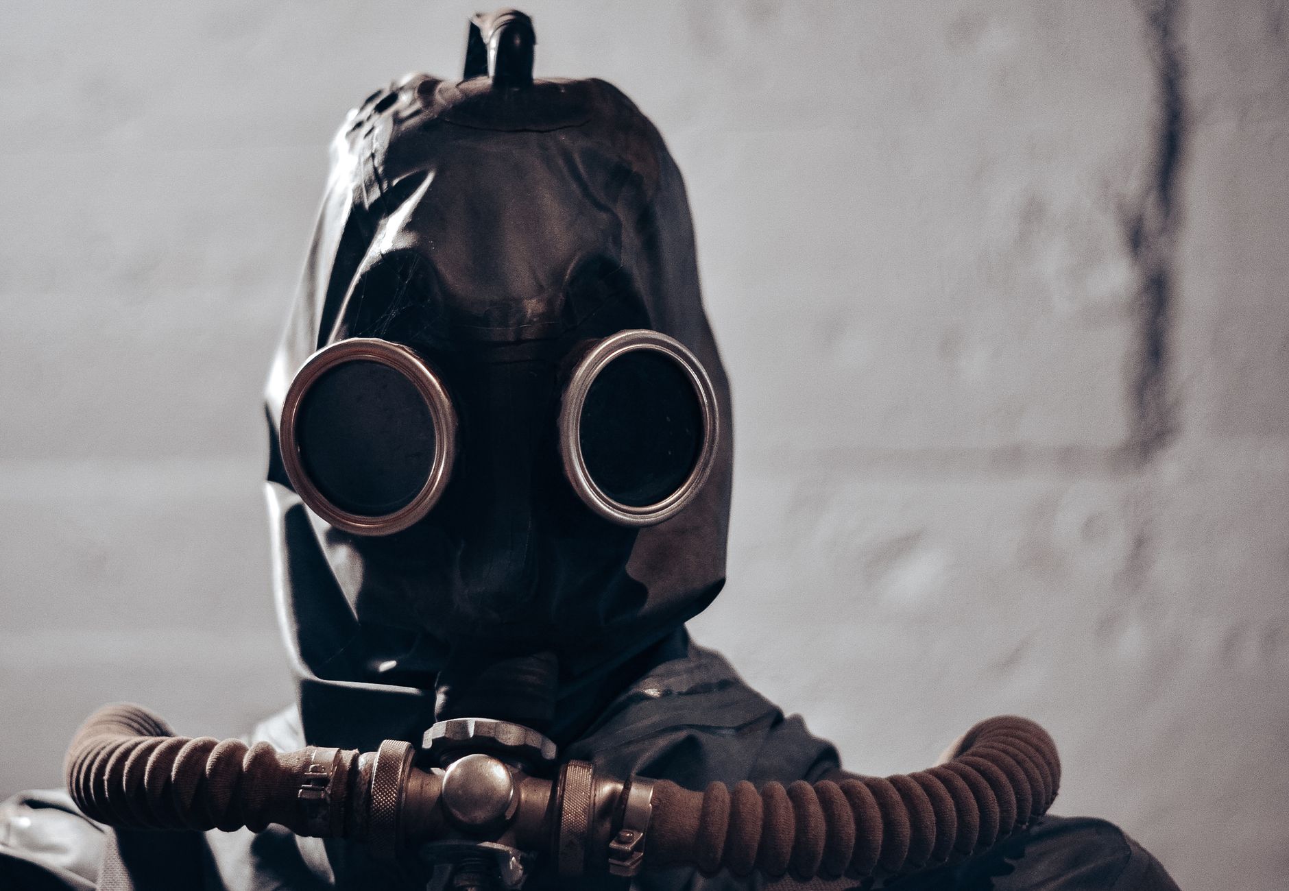 Dramatic portrait of an individual wearing a gas mask, evokes themes of protection and secrecy.