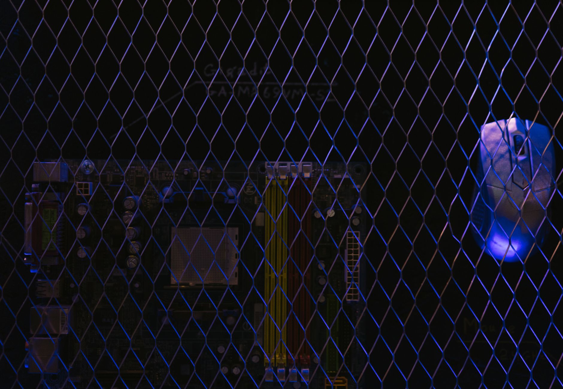 Artistic image featuring a circuit board viewed through a wire mesh, highlighting technology security.