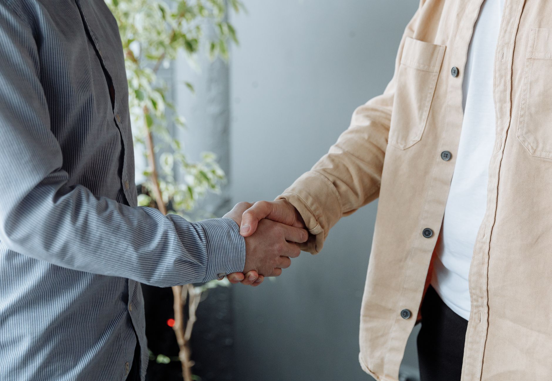 A close-up image of two businesspeople shaking hands in an office environment symbolizing agreement and partnership.