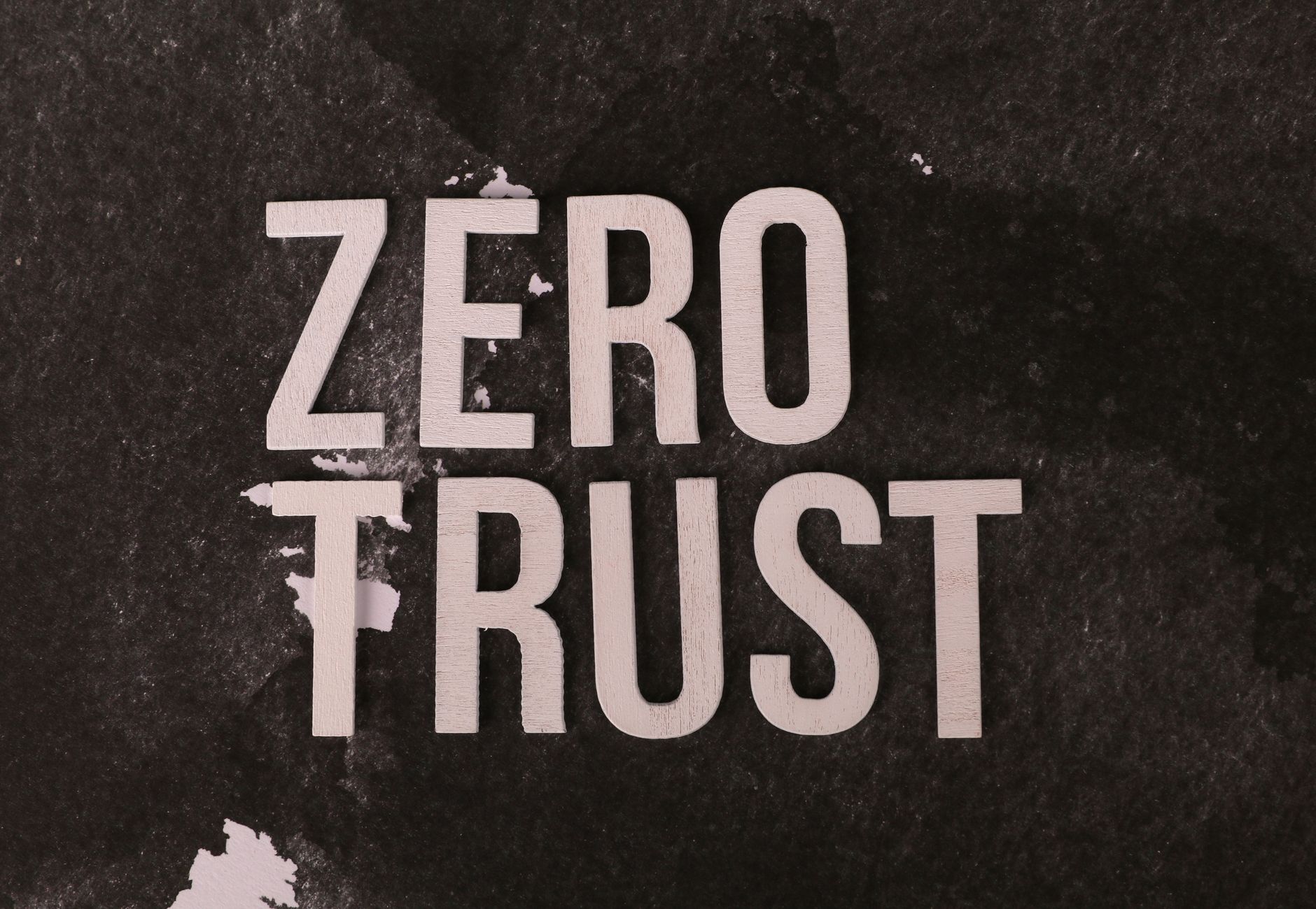 Wooden text reading 'Zero Trust' on a black textured background emphasizing security.